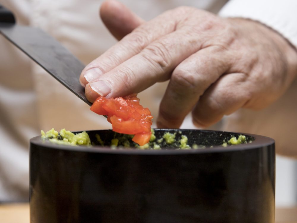 chef-putting-tomatoes-avocado